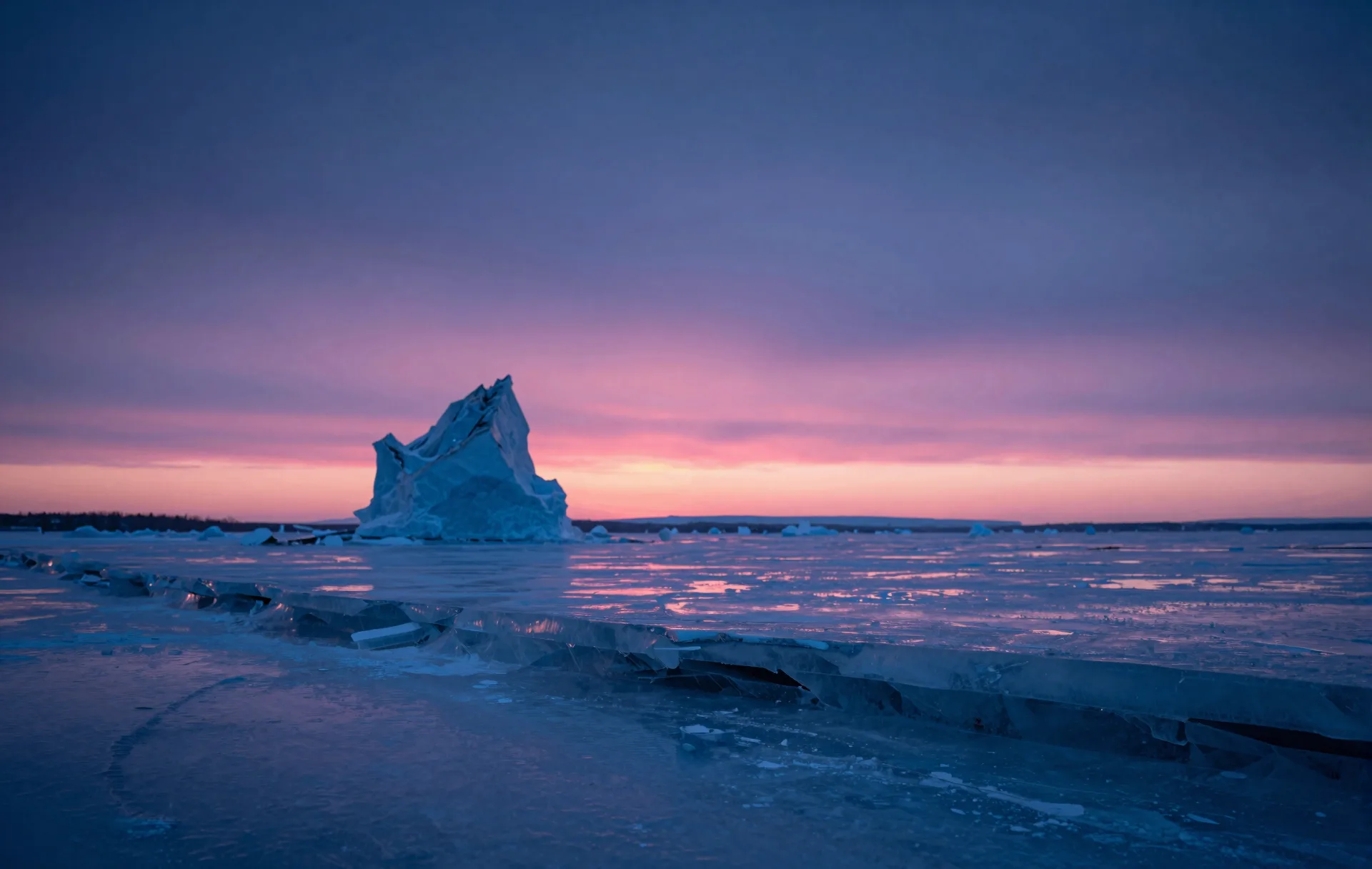 Distant layered ice formation under a deep electric-blue sky, magenta horizon line