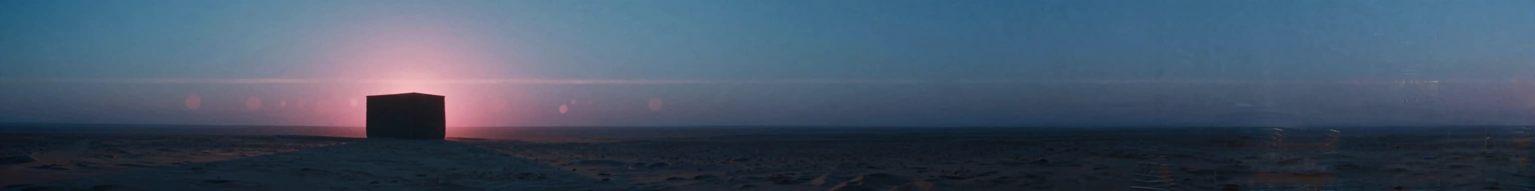 Distant rectangular monolith on an open plain, anamorphic widescreen framing with twin-light treatment