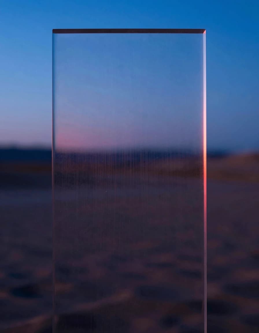 A single iridescent translucent glass slab in vertical slice, interior revealing color refraction through its translucent layers, electric-blue and hot-pink light bleeding through the strata.