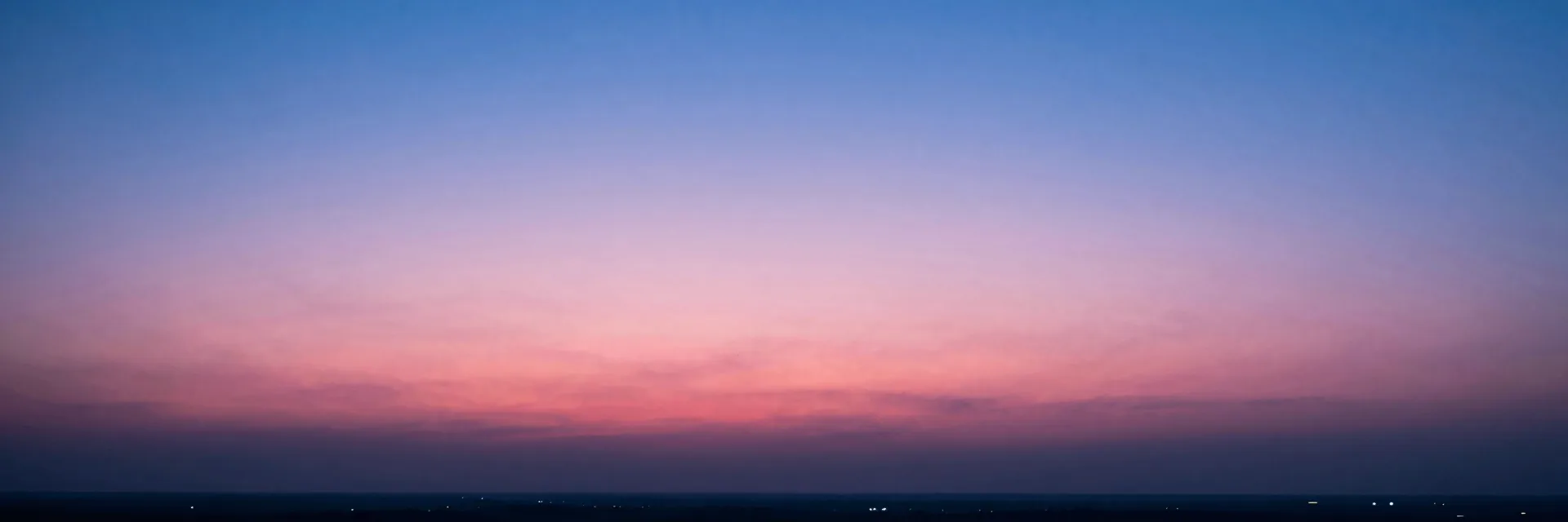 Pure-atmosphere of the gradient pink and blue dusk sky stretching across the entire frame at last light, no columns in frame.