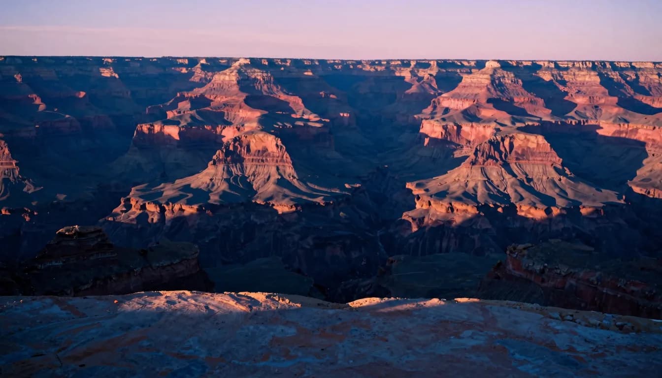 Dusk light raking across the canyon wall creating dramatic shadow play