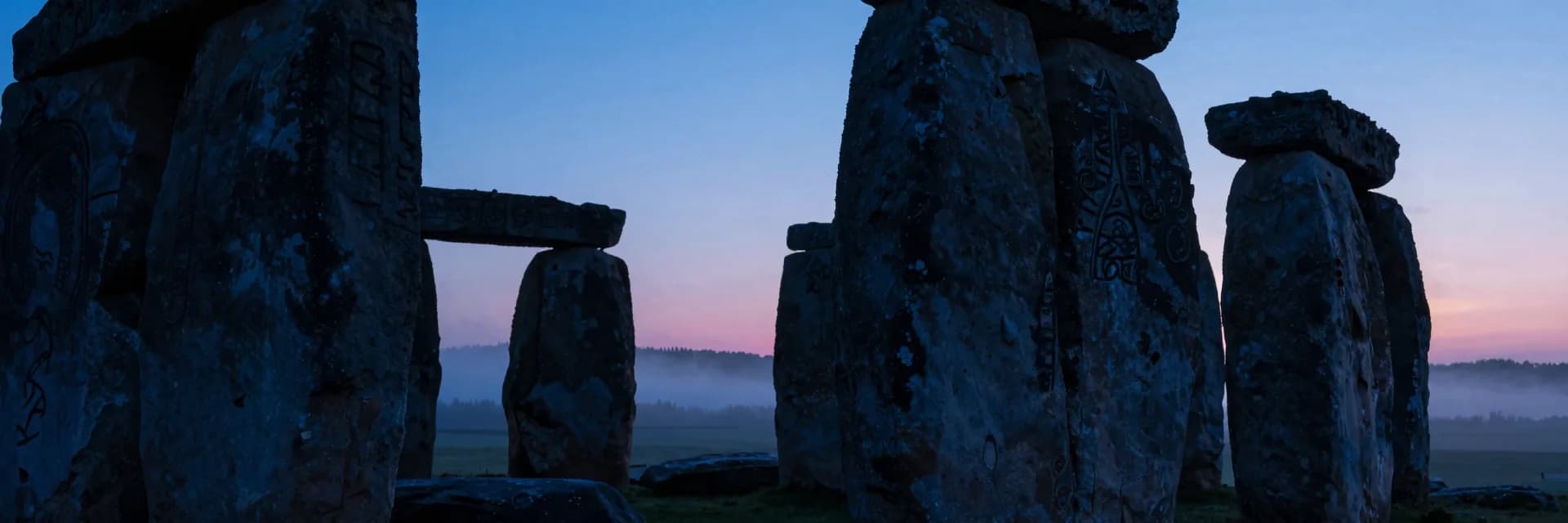 An ultra-wide perspective from inside the stone circle looking out through the gap between two pillars toward the distant horizon at dusk.