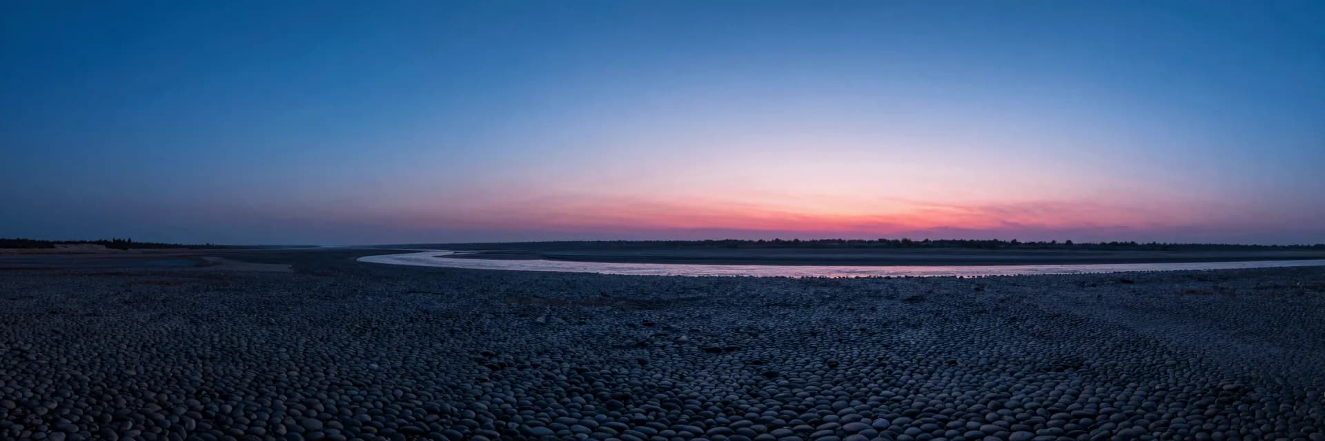 Wide atmospheric scene of layered haze and deep blue gradient sky, single hot-pink horizon line glowing across the lower frame.