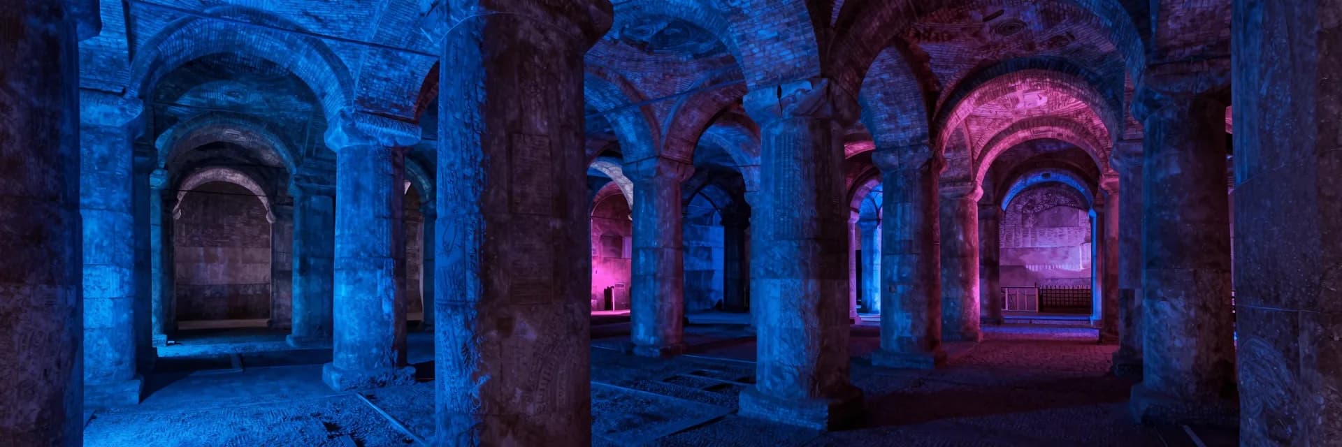 ultra-wide strip of cavern arch interior with electric-blue ambient and hot-pink rim accent - hero image for the $1000/month DTC data warehouse guide