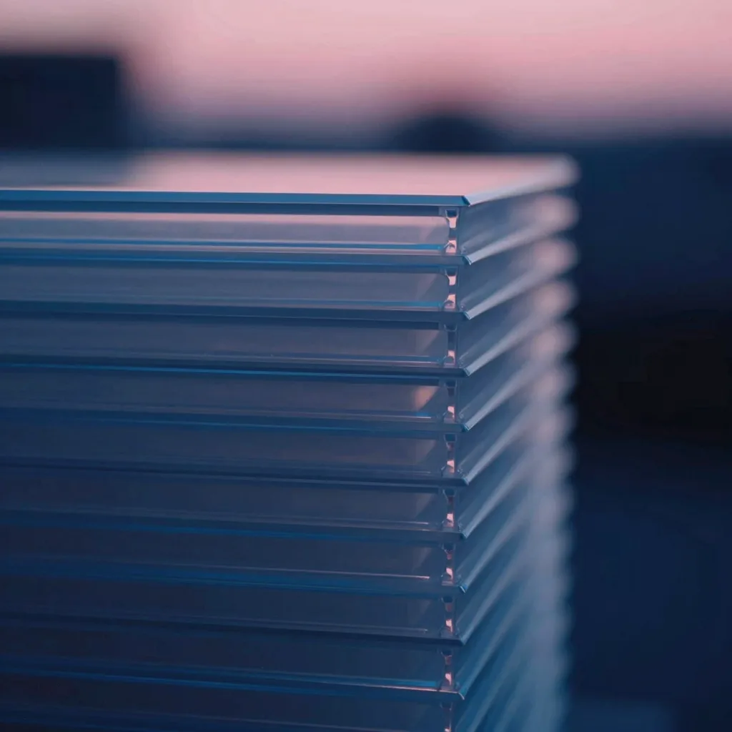 Close-up macro of the edge of a stack of translucent plastic sheets, showing layered translucency and subtle internal glow.