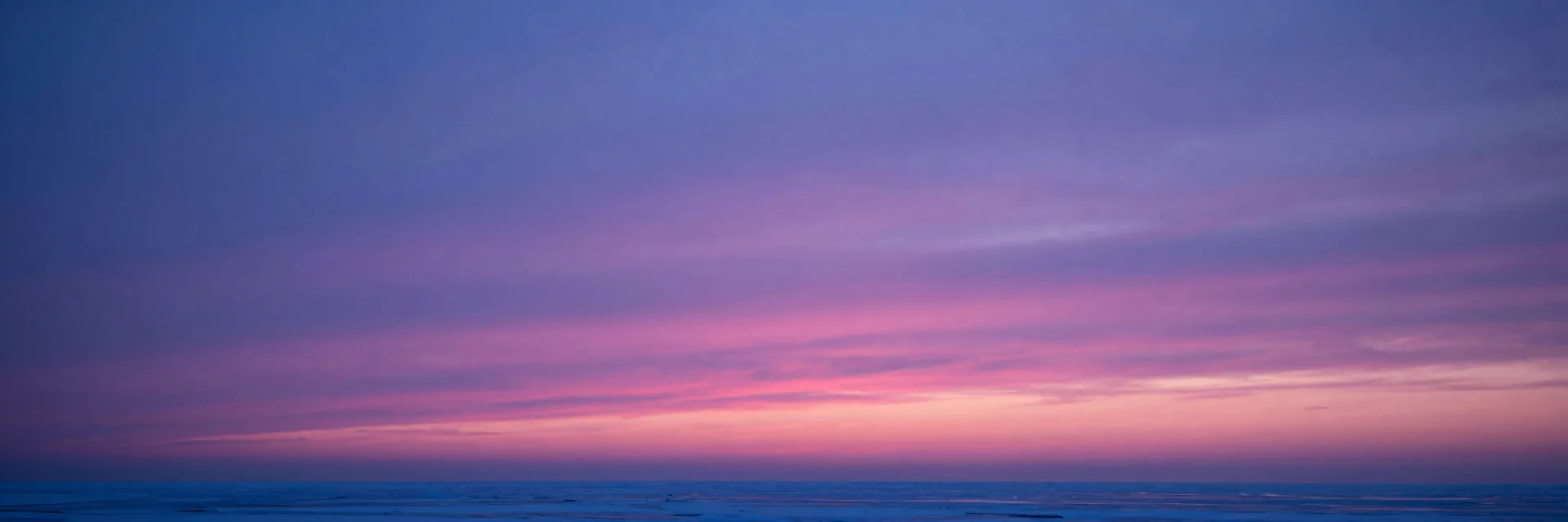 Ultra-wide dusk glow across frozen horizon