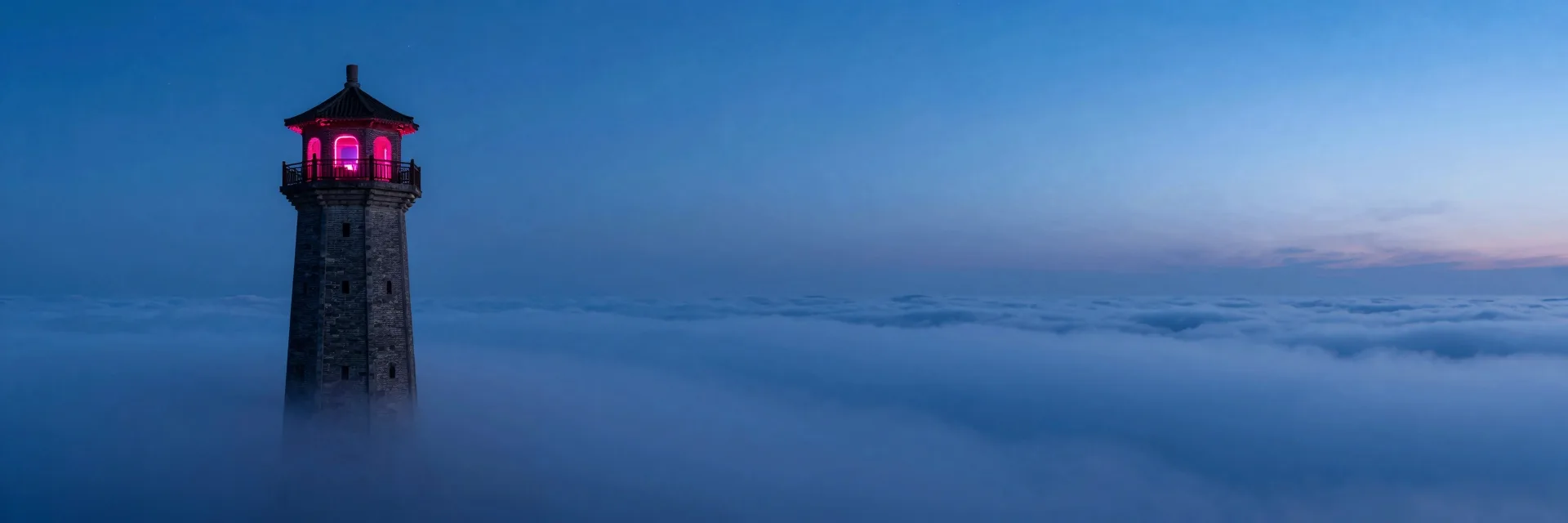 The tower silhouetted against a wide twilight sky, vast horizon stretching across the frame.