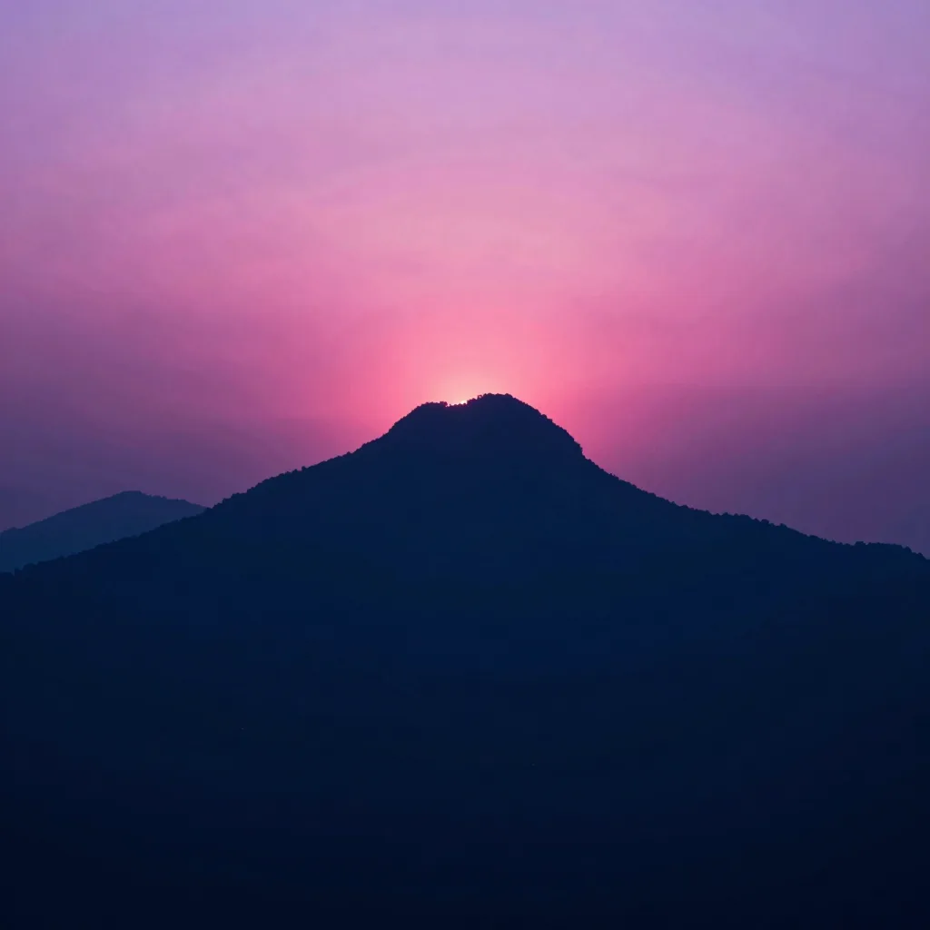 Mountain peak silhouetted against a dusk sky