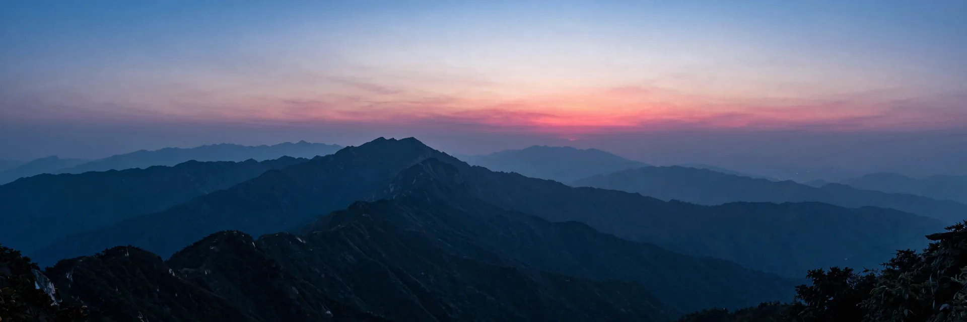 Ultra-wide mountain ridge receding into a vanishing point at dusk