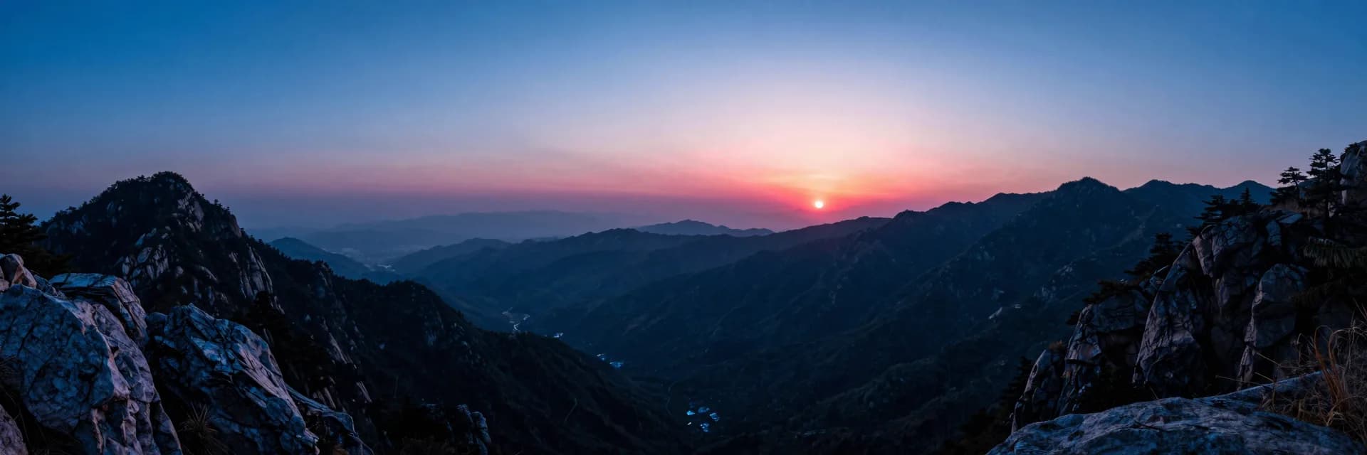 Ultra-wide distant valley between mountain ranges at dusk
