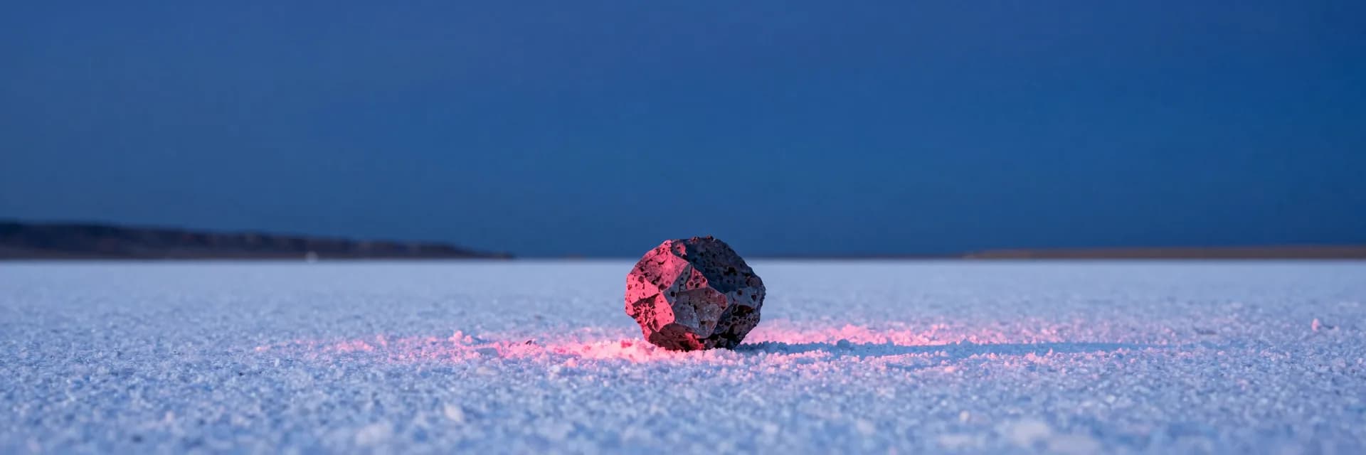 ultra-wide strip of dark erratic boulder on a white salt flat under electric-blue sky - companion image for the MCP vs Skills vs Tools comparison