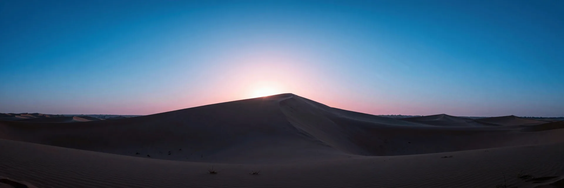 ultra-wide strip of dune ridge under electric-blue sky with hot-pink low sun grazing the crest - companion image for the Meta ads CBO vs ABO 2026 structure guide