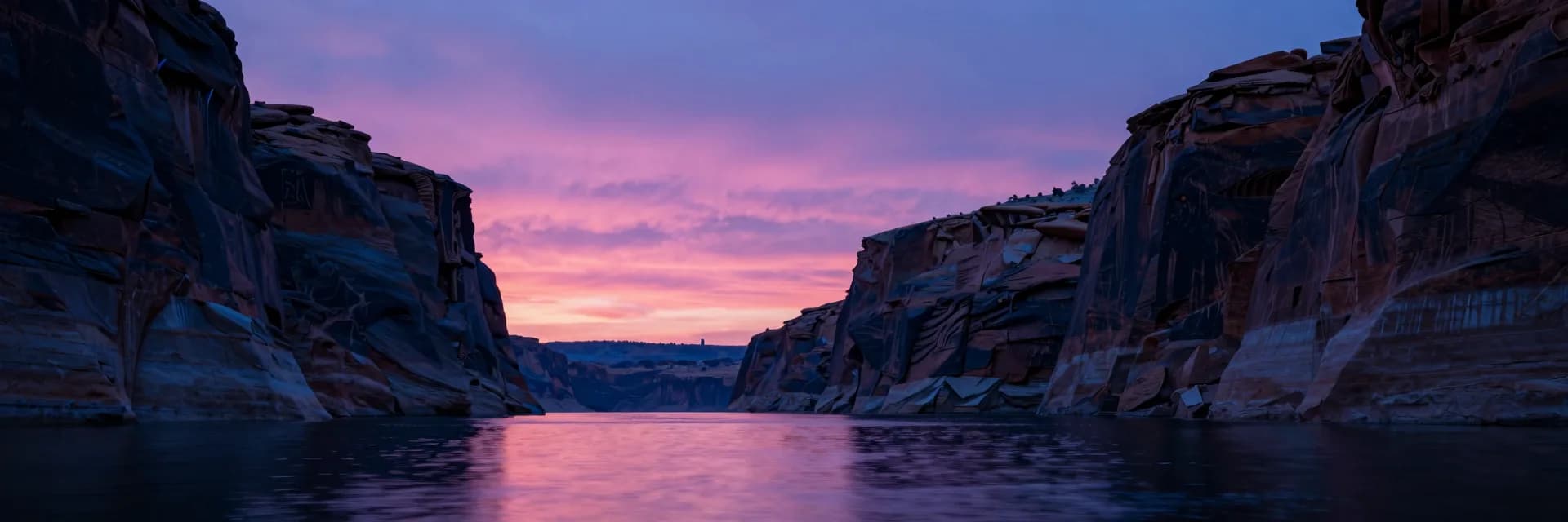 Ultra-wide of the canyon opening framing a vast pink and purple sunset sky and distant horizon at the canyon mouth, rock walls flanking both sides.