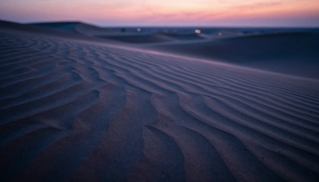 Close-up wind-blown sand dune ripple patterns receding to a defocused horizon, no temple in frame, abstract sand texture.