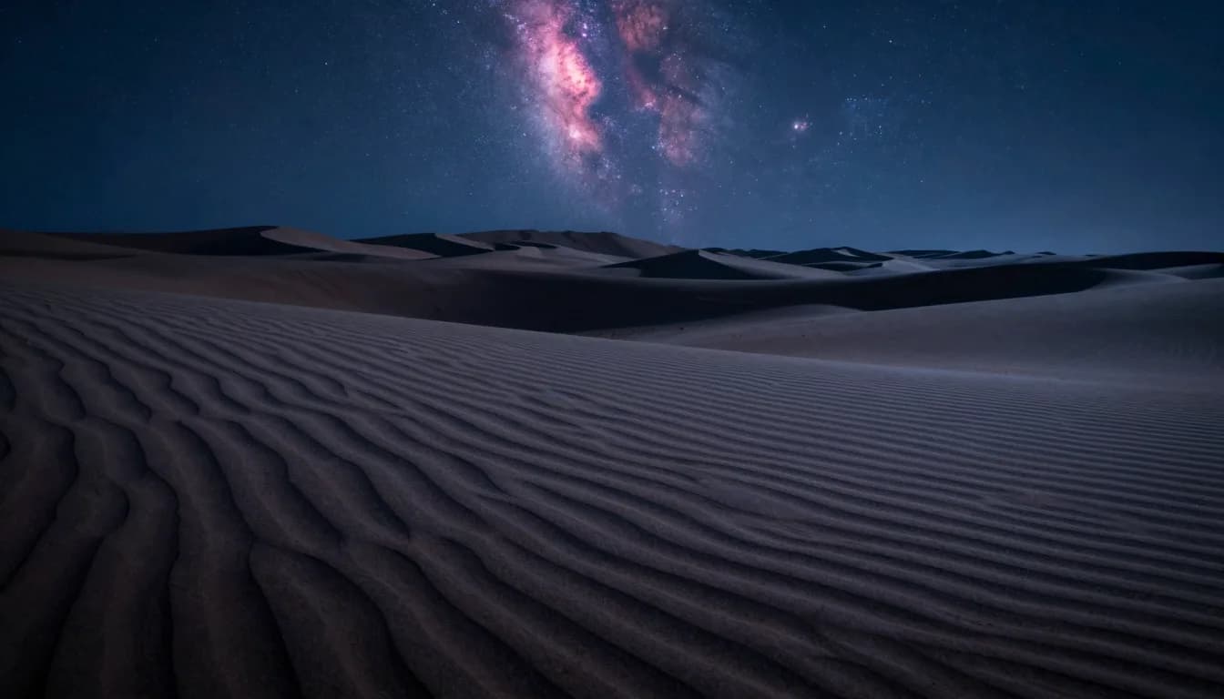 Landscape view of a desert dune throwing a deep shadow under cosmic backlight from the Milky Way.