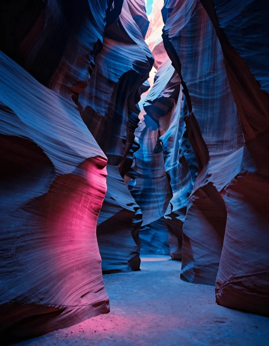 A single immense vertical canyon wall split down the center by a hairline fissure of light filling a tall vertical frame in a deep slot canyon.