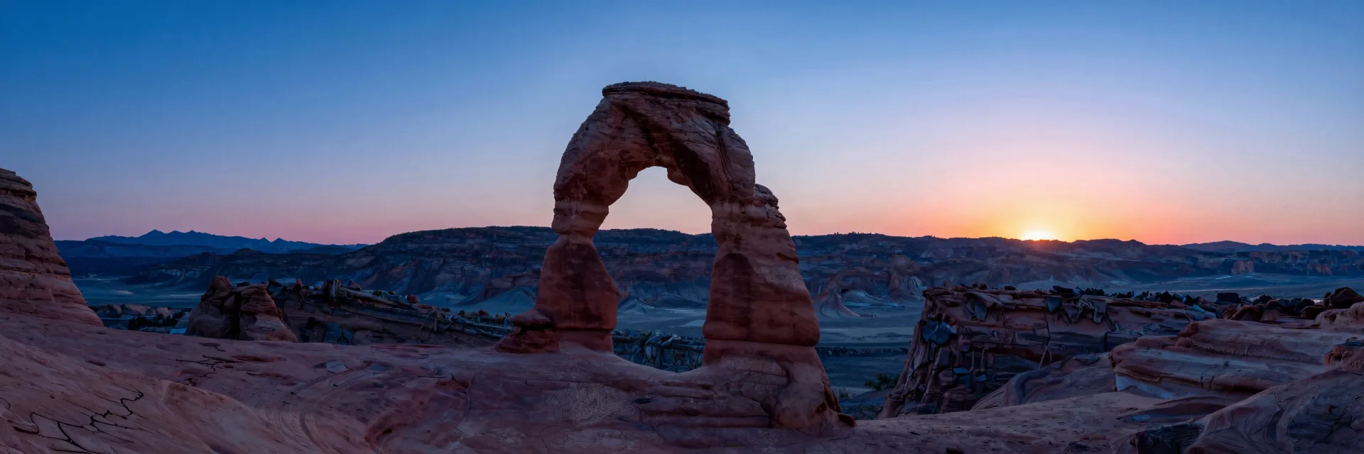 Ultra-wide view of the arch sitting in a vast basin, sweeping panorama framing the single structure.