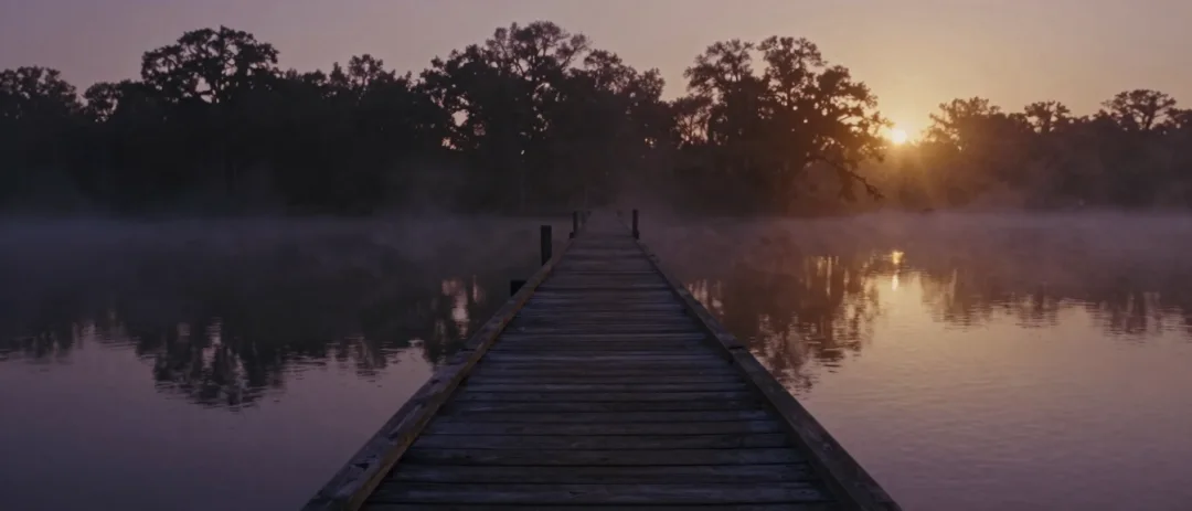 A wooden pier receding into mist over the sound at dawn.