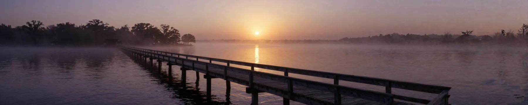 A pier receding into the sound at sunrise.