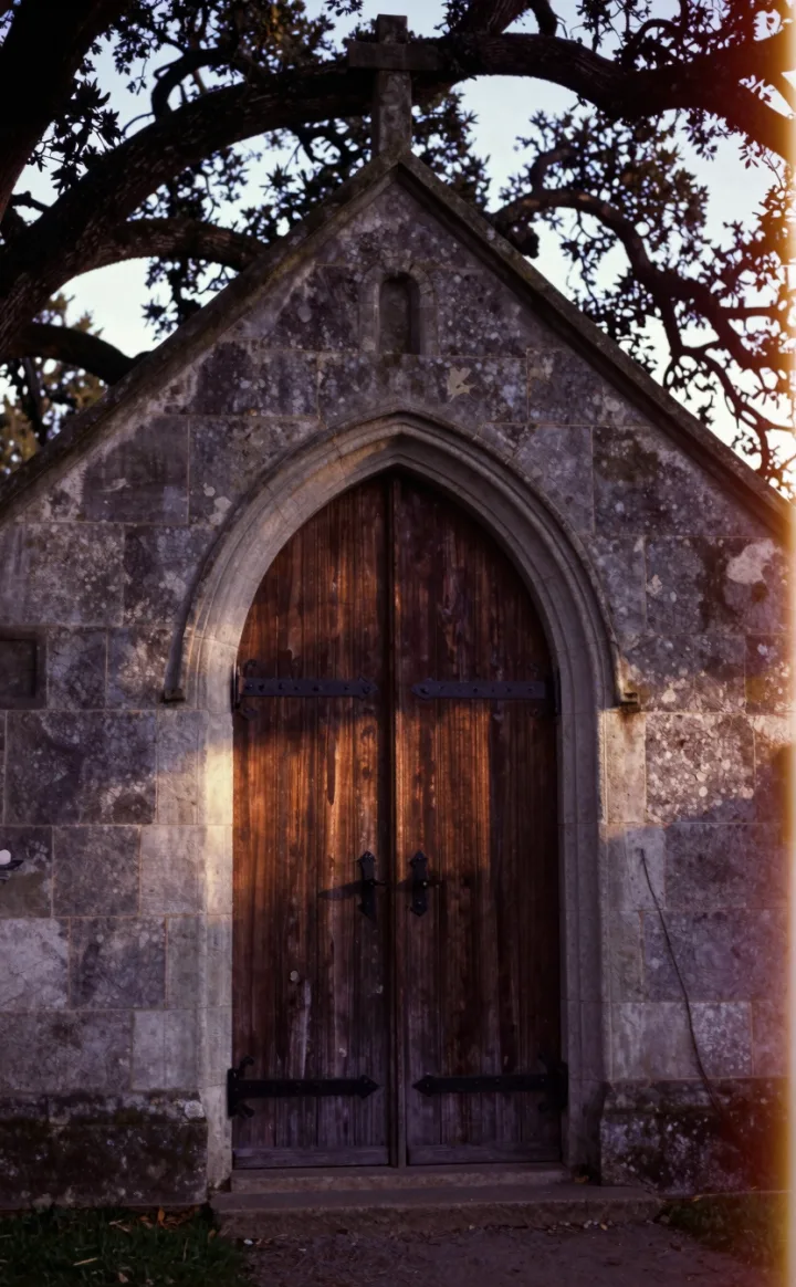 The arched wooden door of a country church.